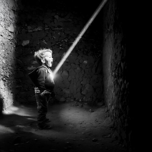 Black and white photograph of a child in a shaft of light, from the HIPA Award 2025 film POWER