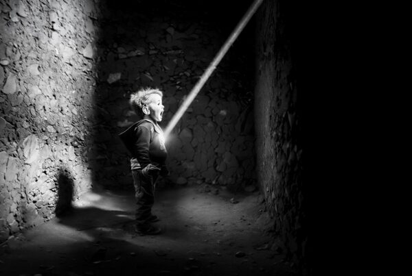 Black and white photograph of a child in a shaft of light, from the HIPA Award 2025 film POWER