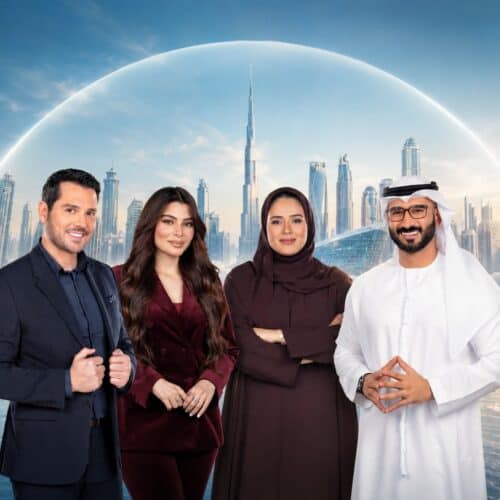 Four Dubai TV presenters in front of the Dubai skyline at sunrise, with the Burj Khalifa and a sweep of light behind them