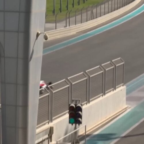 A lone figure beside the barrier of a race circuit
