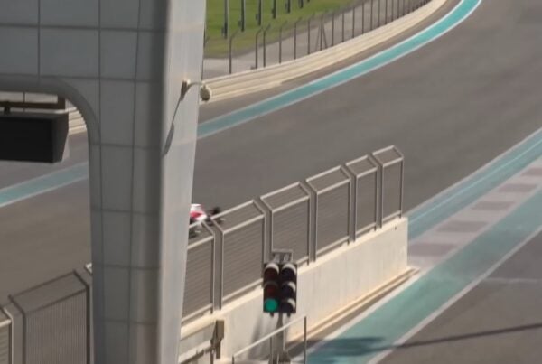 A lone figure beside the barrier of a race circuit