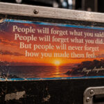 A worn sticker on a black flight case quoting Maya Angelou: people will never forget how you made them feel